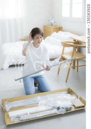 一名婦女正在組裝衣架 130163928