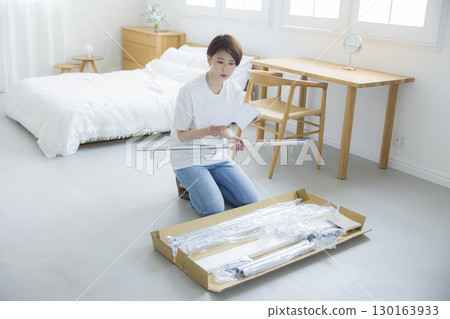 一名婦女正在組裝衣架 130163933