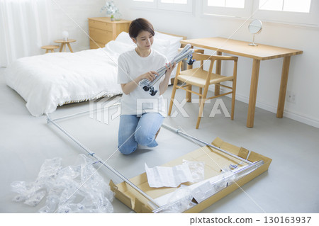 一名婦女正在組裝衣架 一名婦女正在組裝衣架 130163937