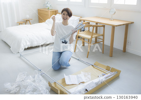 A woman assembling a clothes rack 130163940