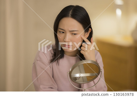 一位女士晚上在臥室進行皮膚護理 130163978