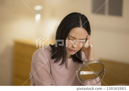 一位女士晚上在臥室進行皮膚護理 130163983