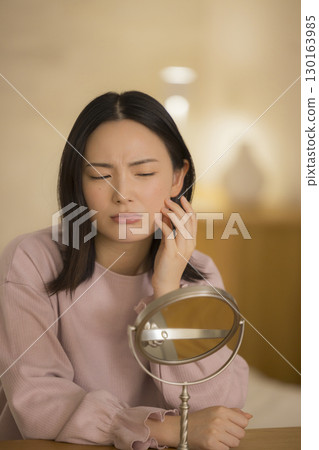 A woman doing skin care at night in her bedroom 130163985