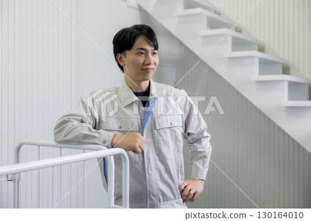 一名身穿工作服的男子在倉庫裡推著手推車 130164010