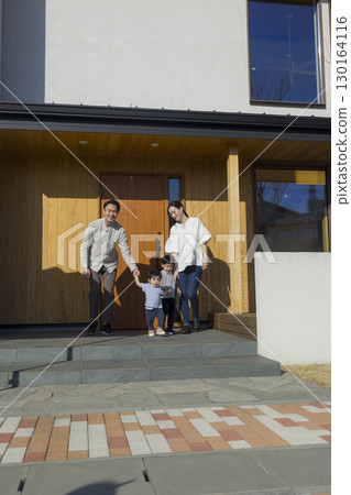 A family standing in front of a family 130164116