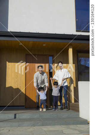 A family standing in front of a family A family standing in front of a family 130164120