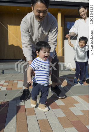 A family standing in front of a family 130164122
