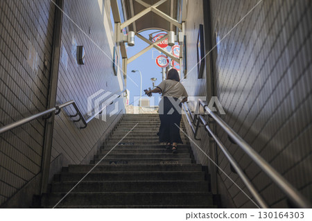 Behind a woman climbing the subway exit stairs Behind a woman climbing the subway exit stairs 130164303