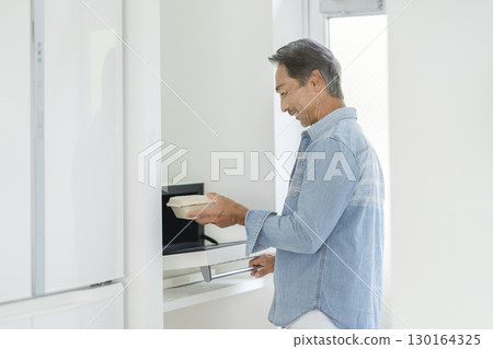 Senior man using a microwave Senior man using a microwave 130164325