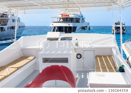 Luxury yachts anchored in clear blue sea 130164359
