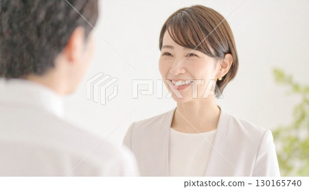 A short-haired female businesswoman is talking to a client A short-haired female businesswoman is talking to a client 130165740