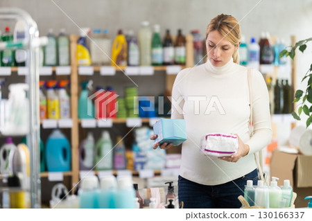 Thoughtful pregnant customer choosing feminine pads in hygiene store Thoughtful pregnant customer choosing feminine pads in hygiene store 130166337