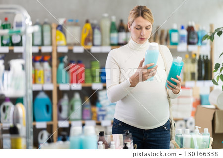 Young pregnant woman choosing shampoo in personal care store Young pregnant woman choosing shampoo in personal care store 130166338