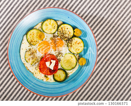 Top view of fried eggs with zucchini 130166371