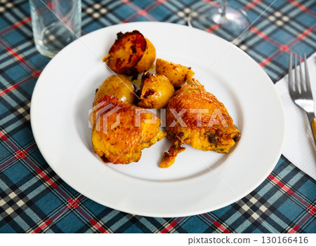 Fried chicken thighs with baked potatoes in skins Fried chicken thighs with baked potatoes in skins 130166416