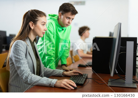 Female teacher explaining task solution to young boy 130166430