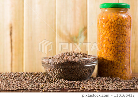 Raw lentils in bowl and canned lentils in jar 130166432