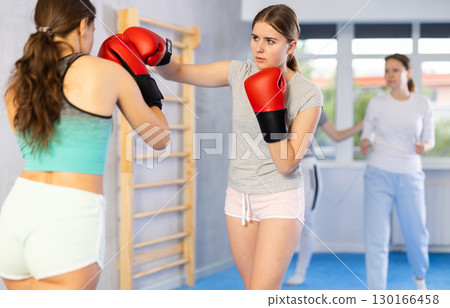 Teen girls in punch mitts boxing 130166458