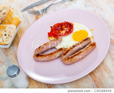 Breakfast of fried eggs with sausage and tomatoes Breakfast of fried eggs with sausage and tomatoes 130166459