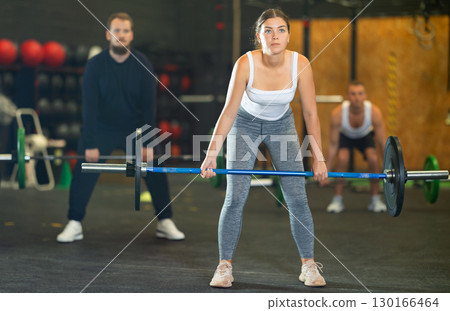 Girl performing barbell Romanian deadlif during cross training Girl performing barbell Romanian deadlif during cross training 130166464