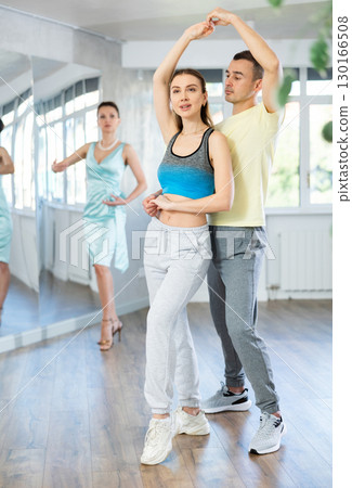 Smiling woman and man dancing bachata in choreography studio Smiling woman and man dancing bachata in choreography studio 130166508