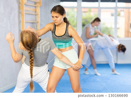 Teen girl practicing basic protection skills in training bout Teen girl practicing basic protection skills in training bout 130166690