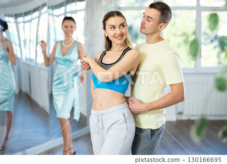 Smiling woman enjoying merengue with man in latin dance class 130166695