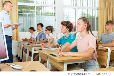 Pupils sitting in class and listening Pupils sitting in class and listening 130166698