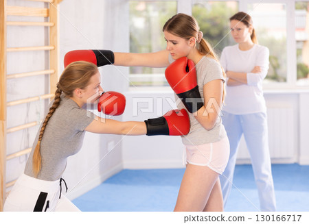Teen girls in punch mitts boxing Teen girls in punch mitts boxing 130166717