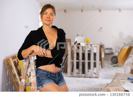Portrait of a half-naked girl in short shorts in renovated room Portrait of a half-naked girl in short shorts in renovated room 130166738