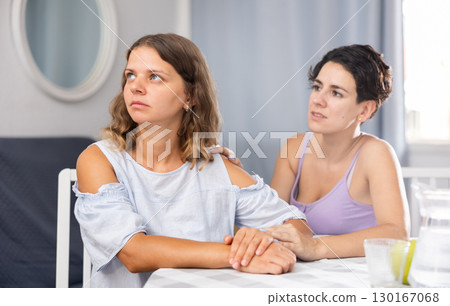 Upset disappointed woman sitting at home while girl calming her 130167068