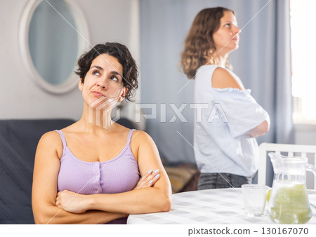 Two young adult women ignoring each other after home quarrel 130167070