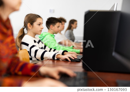 Schoolgirl using PC during computer science lesson 130167093
