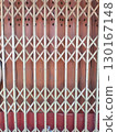 Wooden gate with lattice design and star shaped cutouts at top, set against reddish brown background, creating decorative and functional barrier 130167148