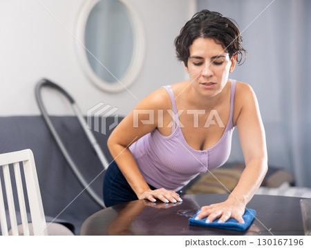 Woman with rag cleaning room at home 130167196