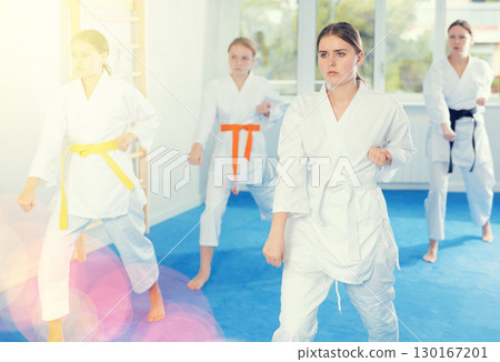 Young female students repeat position and perform sequence of punches and painful techniques kata 130167201