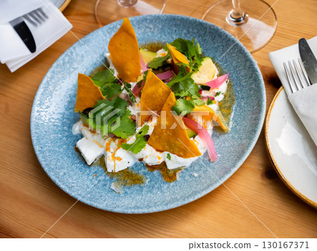 Mexican style salad with burrata, greens, avocado, tortilla chips 130167371