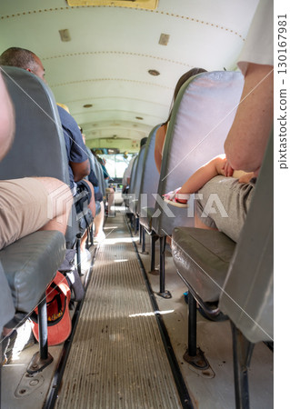 Passengers sit quietly on a bus during mid-afternoon travel in a vibrant community setting Passengers sit quietly on a bus during mid-afternoon travel in a vibrant community setting 130167981