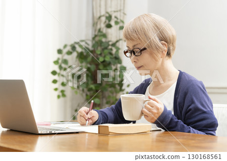 A senior woman operating a computer 130168561