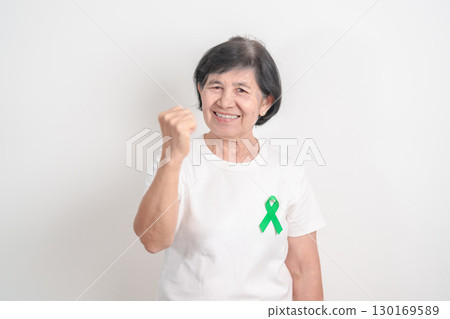 Elderly with Green Ribbon for concept of July Eye Injury Prevention month, January Glaucoma Awareness month, February Gallbladder and Bile duct and October Liver cancer. Health and world cancer day 130169589
