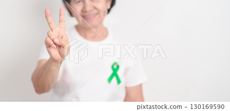 Elderly with Green Ribbon for concept of July Eye Injury Prevention month, January Glaucoma Awareness month, February Gallbladder and Bile duct and October Liver cancer. Health and world cancer day Elderly with Green Ribbon for concept of July Eye Injury Prevention month, January Glaucoma Awareness month, February Gallbladder and Bile duct and October Liver cancer. Health and world cancer day 130169590