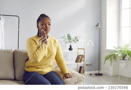 Woman with severe toothache touches her swollen cheek. 130170398