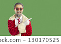 Glad male Santa Claus dressed in red clothing indicating index finger on copy space 130170525