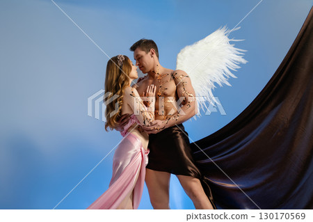 Romantic couple in artistic costumes with angel wings posing together Romantic couple in artistic costumes with angel wings posing together 130170569