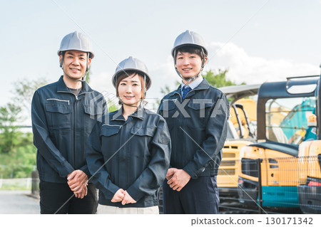 重型機械前穿著工作服的男女建築工人 130171342