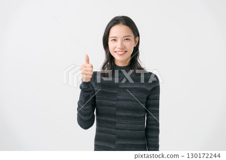 A woman giving a thumbs up and giving a thumbs up pose 130172244