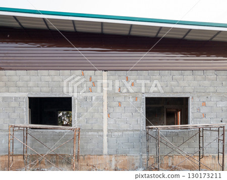 Small Rural House Under Construction with Scaffolding. Small Rural House Under Construction with Scaffolding. 130173211