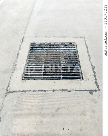 Black Metal Drain Grate on Concrete Road. 130173212