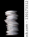 Column of zigzag stacked silver coins, against black background. Stacked circulated silver bullion coins, with reeded edges, of one troy ounce of 99.9 percent pure silver each. 999 fine silver coins. 130173312