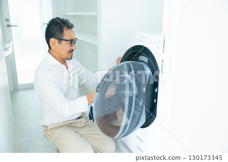 Housework: Middle-aged man doing laundry 130173345